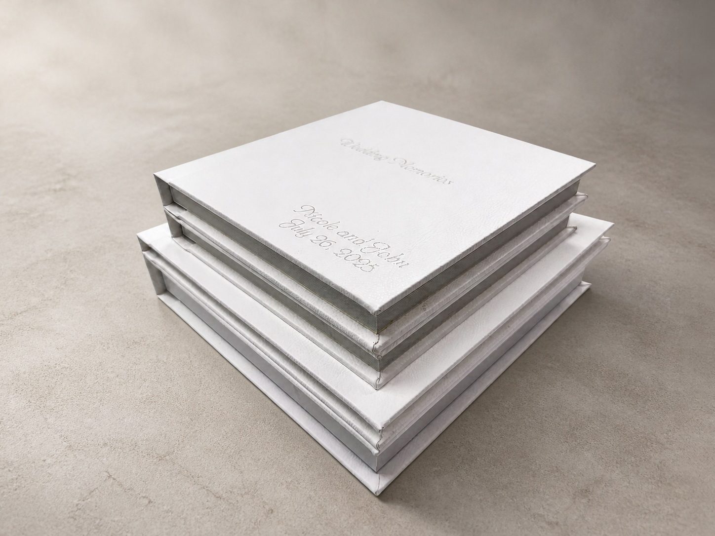 Stack of white leather wedding albums